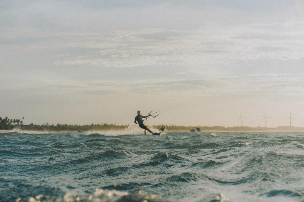 a man riding a wave on a surfboard in the ocean at KANAHA BEACH VILLA in Icaraí