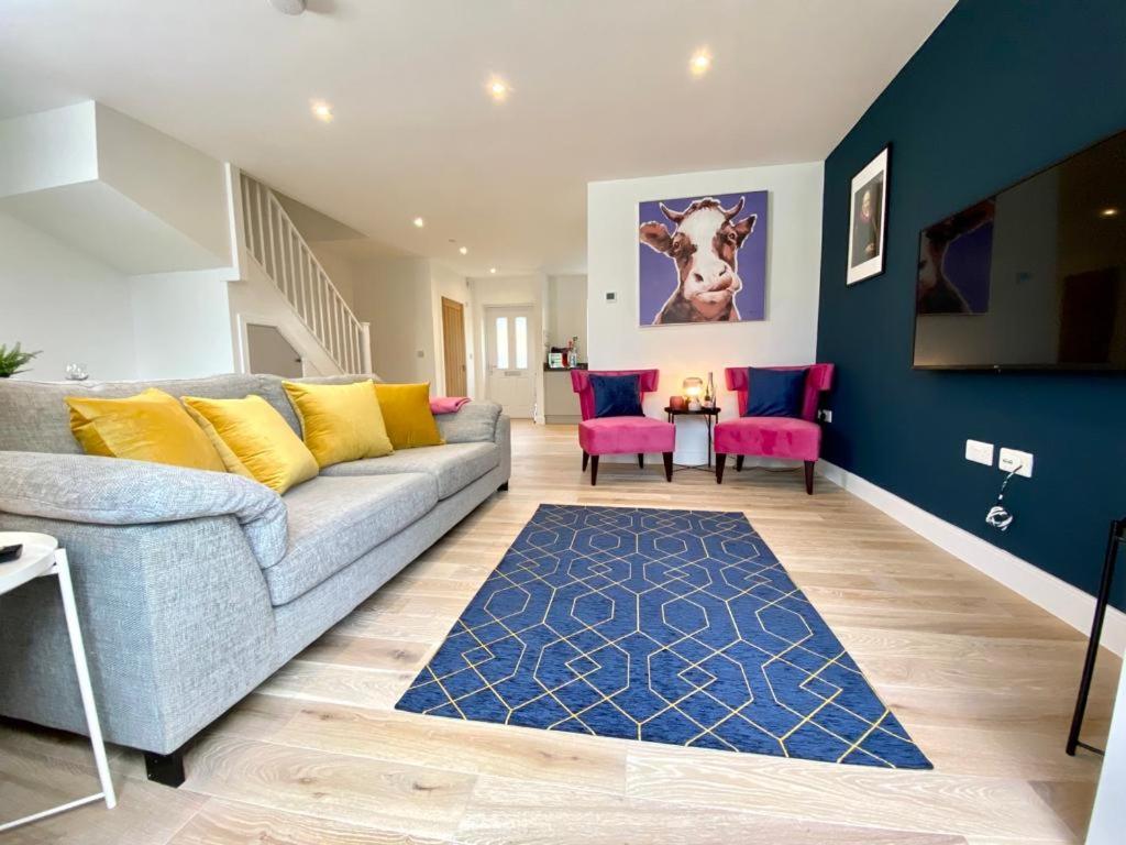 a living room with a couch and pink chairs at NEW Beautiful Large 3 bedroom House - 5 Minutes to the nearest Beach! - Great Location - Garden - Parking - Fast WiFi - Smart TV - Newly decorated - sleeps up to 7! Close to Poole & Bournemouth & Sandbanks in Lytchett Minster
