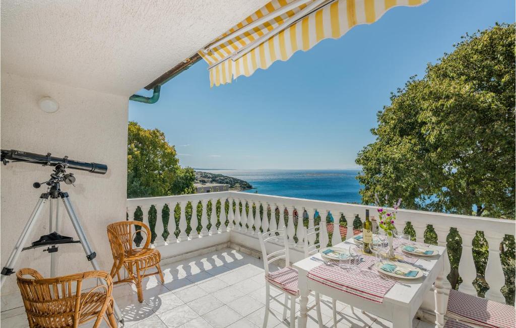 a table on a balcony with a view of the ocean at Stunning Apartment In Stara Baska With 1 Bedrooms And Wifi in Stara Baška
