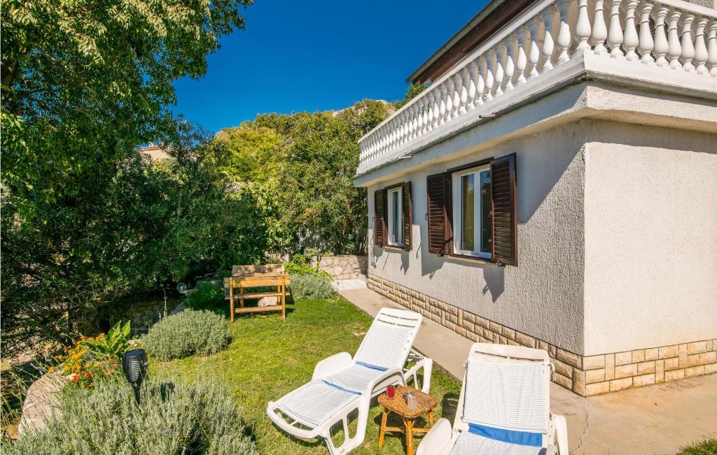 grupa krzeseł siedzących na podwórku domu w obiekcie 1 Bedroom Nice Apartment In Stara Baska w mieście Stara Baška