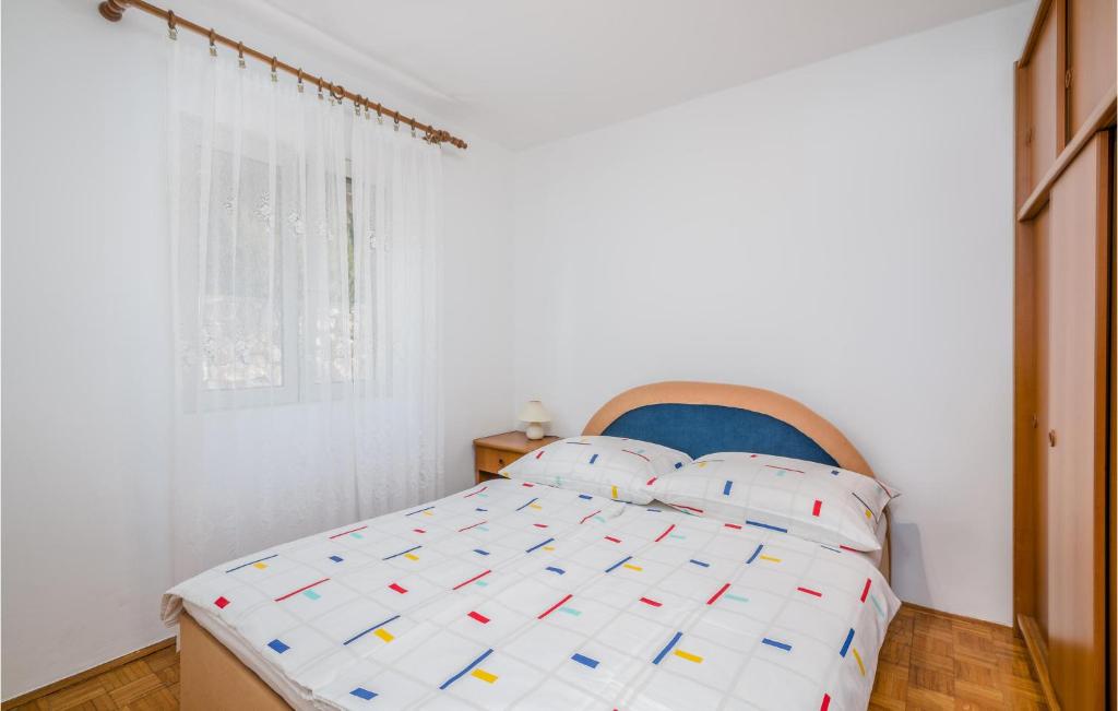 biała sypialnia z łóżkiem z niebieskim zagłówkiem w obiekcie 1 Bedroom Nice Apartment In Stara Baska w mieście Stara Baška