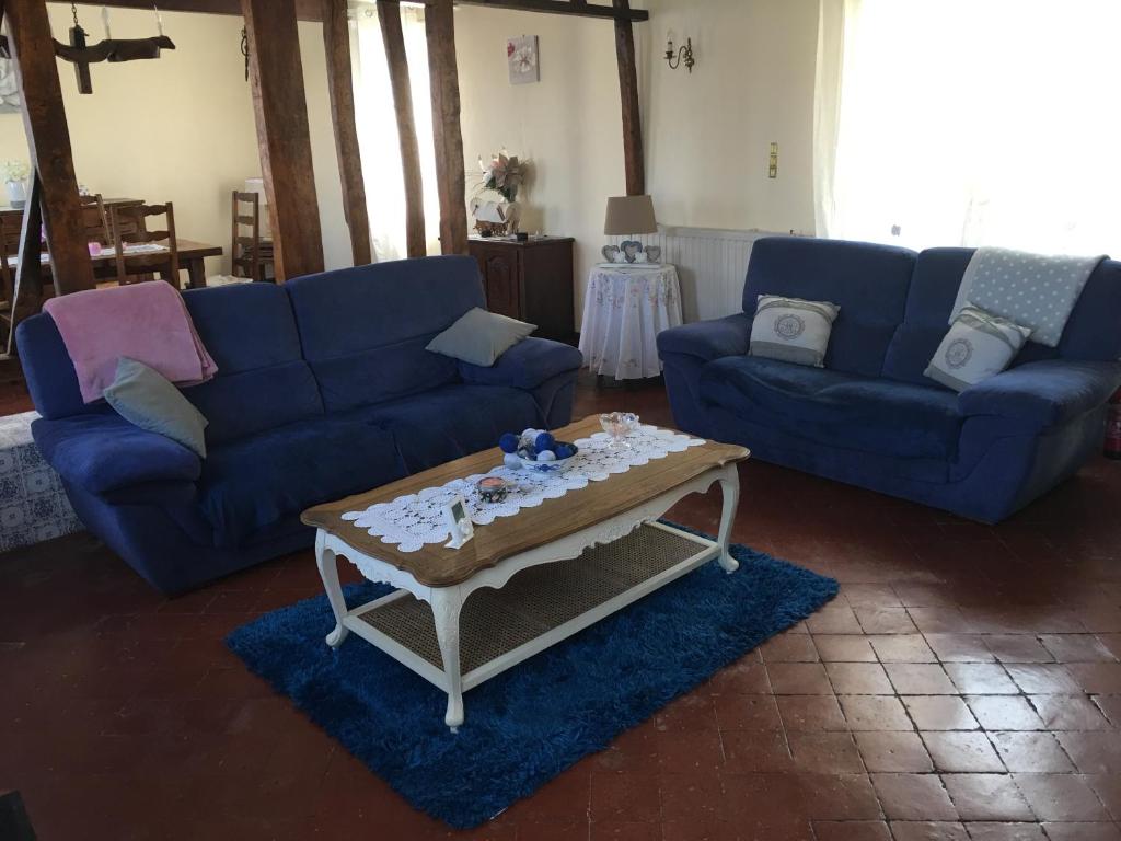 un soggiorno con divano blu e tavolino da caffè di Le Clos Mesnil a Le Mesnil-Réaume