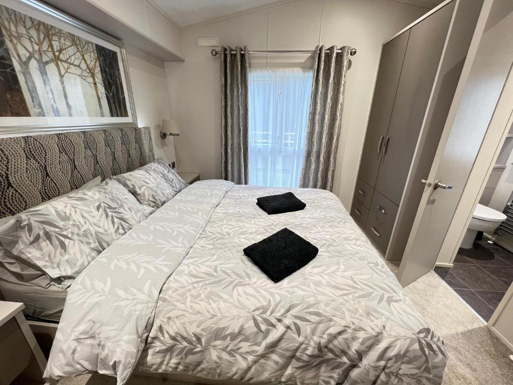 - une chambre avec un lit doté de 2 oreillers noirs dans l'établissement Lakes End, Dog Friendly, à South Cerney