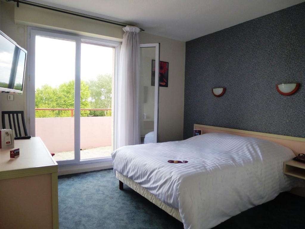 1 dormitorio con cama y ventana grande en Hotel Agena Hagondange, en Hagondange