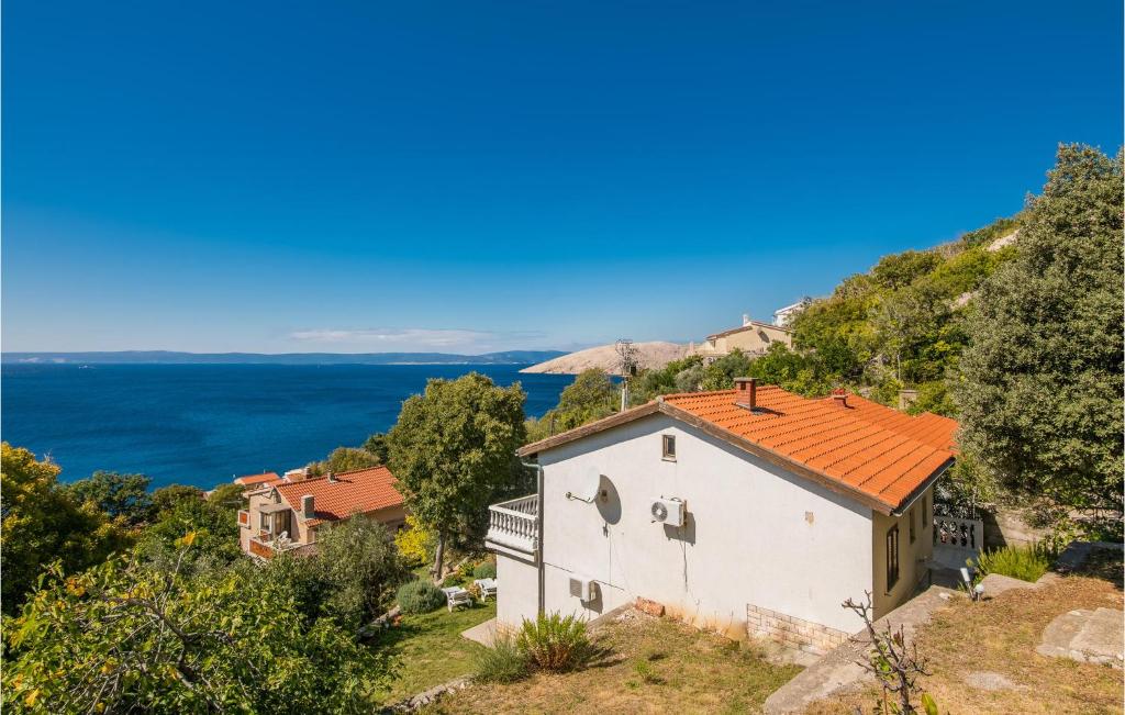 a house on a hill with a view of the ocean at Amazing Apartment In Stara Baska With 1 Bedrooms And Wifi in Stara Baška