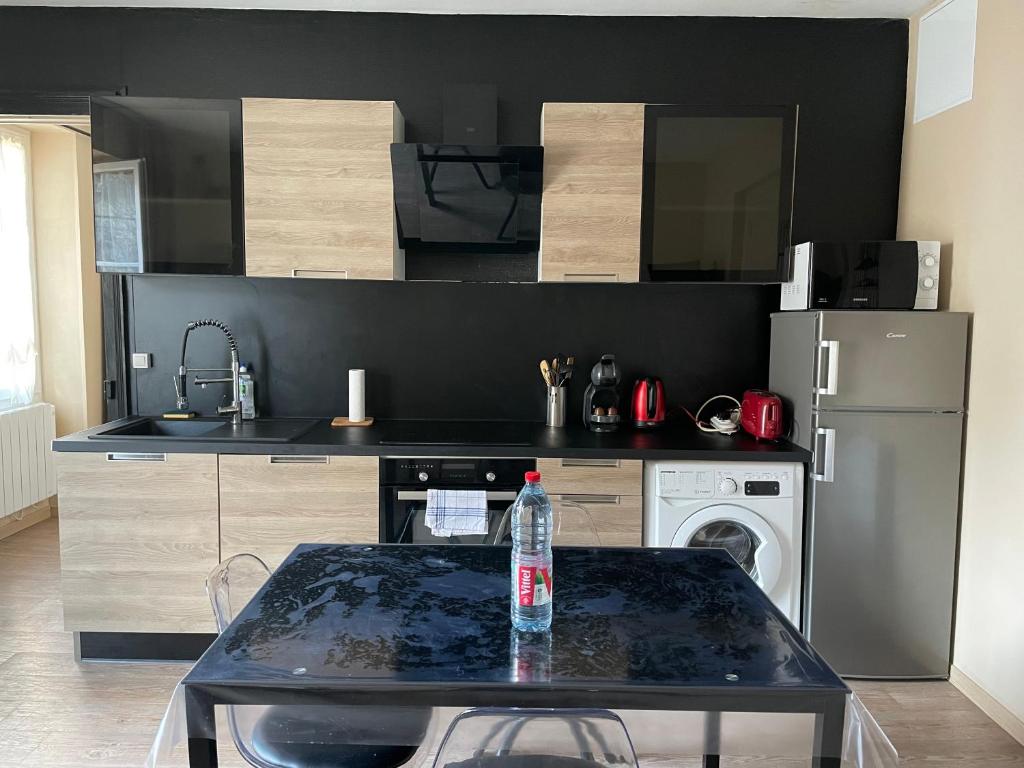 eine Küche mit einem Tisch und einer Wasserflasche darauf in der Unterkunft Appartement 42 m2 à Vittel proche Thermes-SPA in Vittel