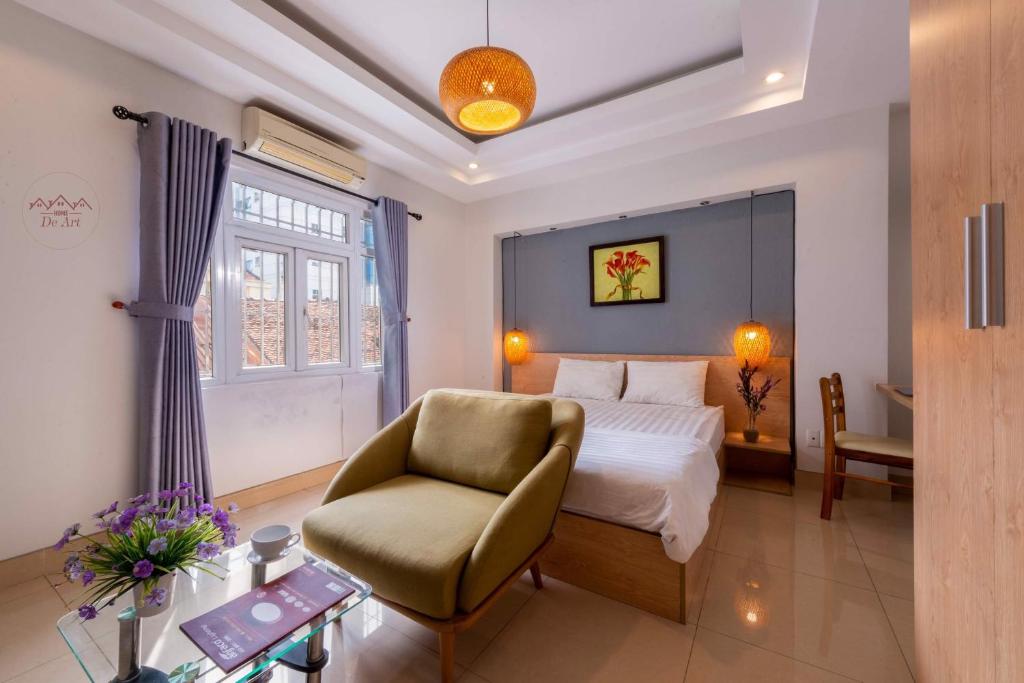 a bedroom with a bed and a chair and a window at Home De Art -303 in Ho Chi Minh City