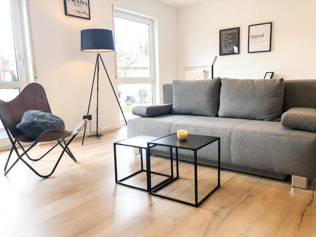 ein Wohnzimmer mit einem Sofa und einem Tisch in der Unterkunft Deluxe Apartments Messe Flughafen in Leinfelden-Echterdingen
