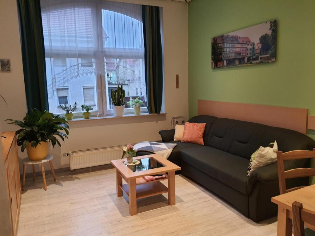 sala de estar con sofá negro y mesa en Ferienwohnung Döring, en Erfurt