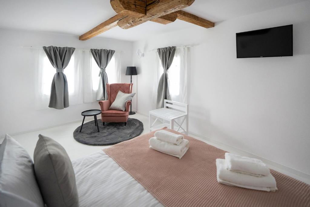 a bedroom with a bed and a chair and a television at Hygge Loft Bucovina in Vama