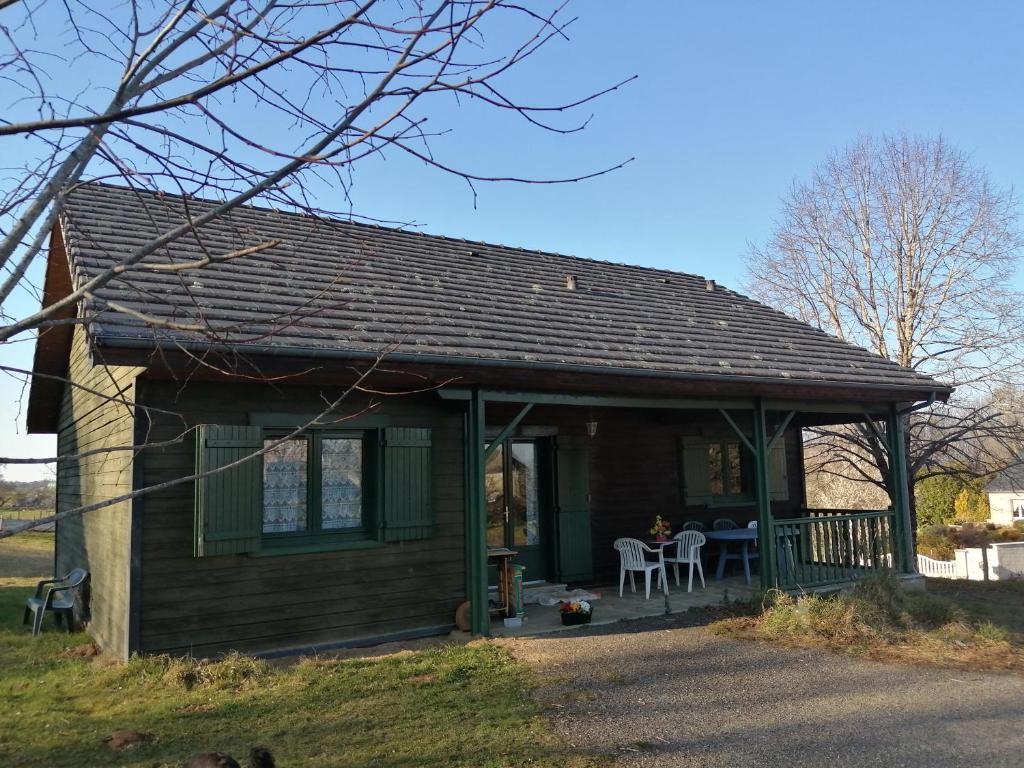 Casa pequeña con porche y mesa en Chalet bois en Neuville