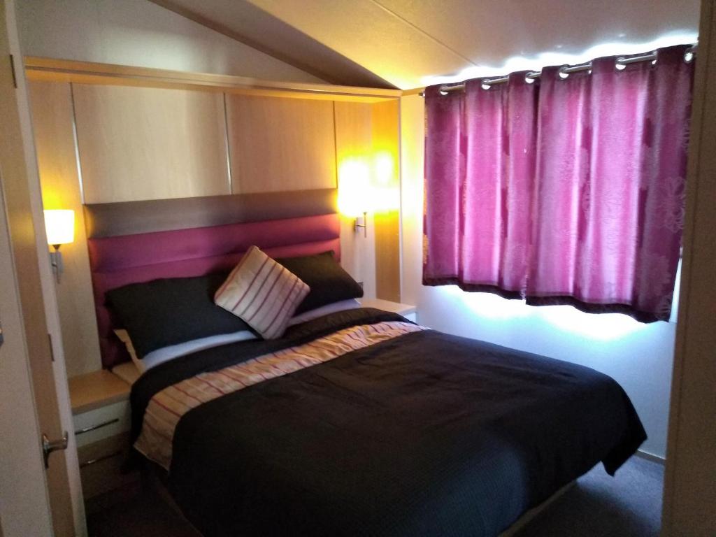 Un pat sau paturi într-o cameră la E3 is a 2 Bedroom 6 berth Lodge on Whitehouse Leisure Park in Towyn near Rhyl close to beach with decking and private parking space This is a pet free caravan