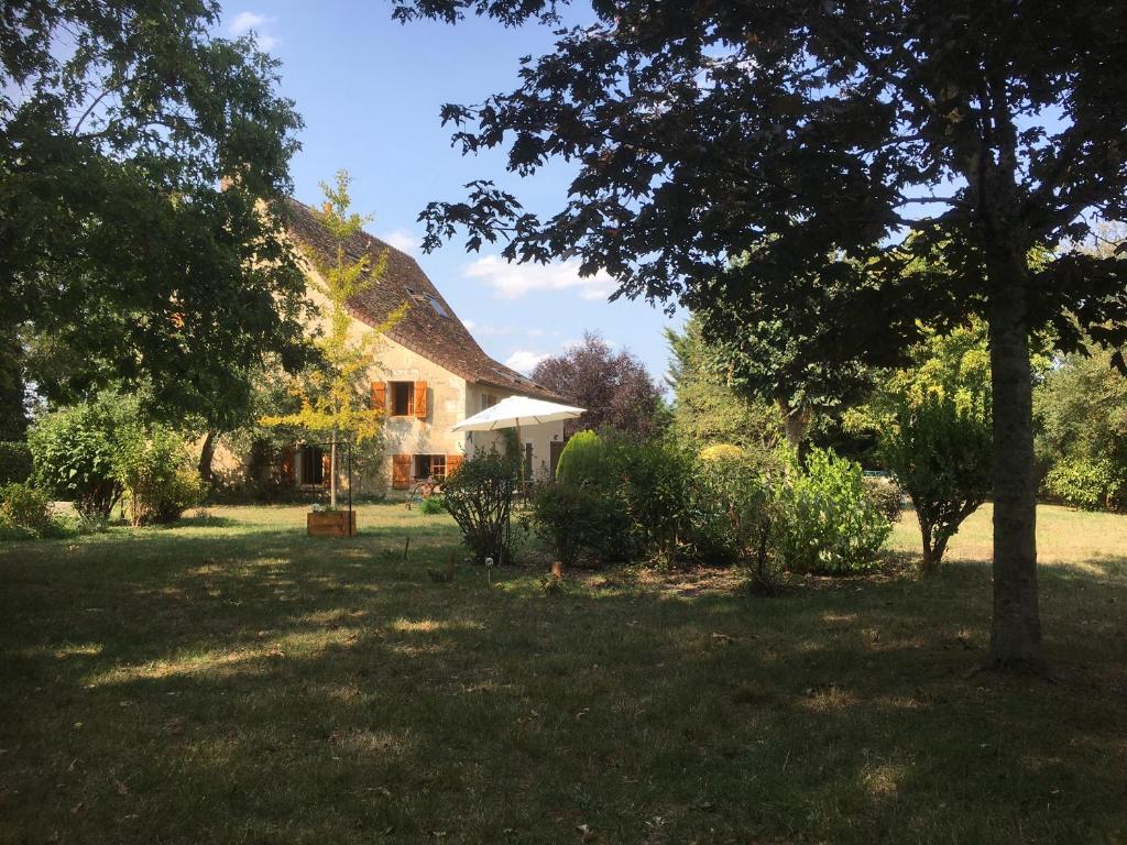 a house with a thatched roof in a yard at La Gentillere “Ancien Ermitage”PNR du Perche 3 * in Brunelles