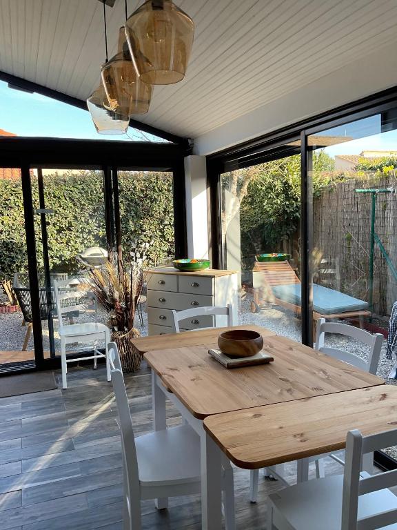 une salle à manger avec une table et des chaises en bois dans l'établissement Location maison de vacances à Sainte-Marie-Plage, à Sainte-Marie-la-Mer