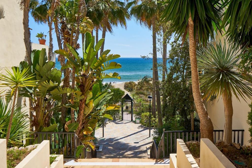 Blick auf den Strand von einem Resort mit Palmen in der Unterkunft OleHolidays 224 Romana Playa con vistas al mar in Marbella