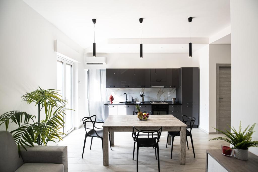 a kitchen and dining room with a table and chairs at CDO Apartment in Capo dʼOrlando