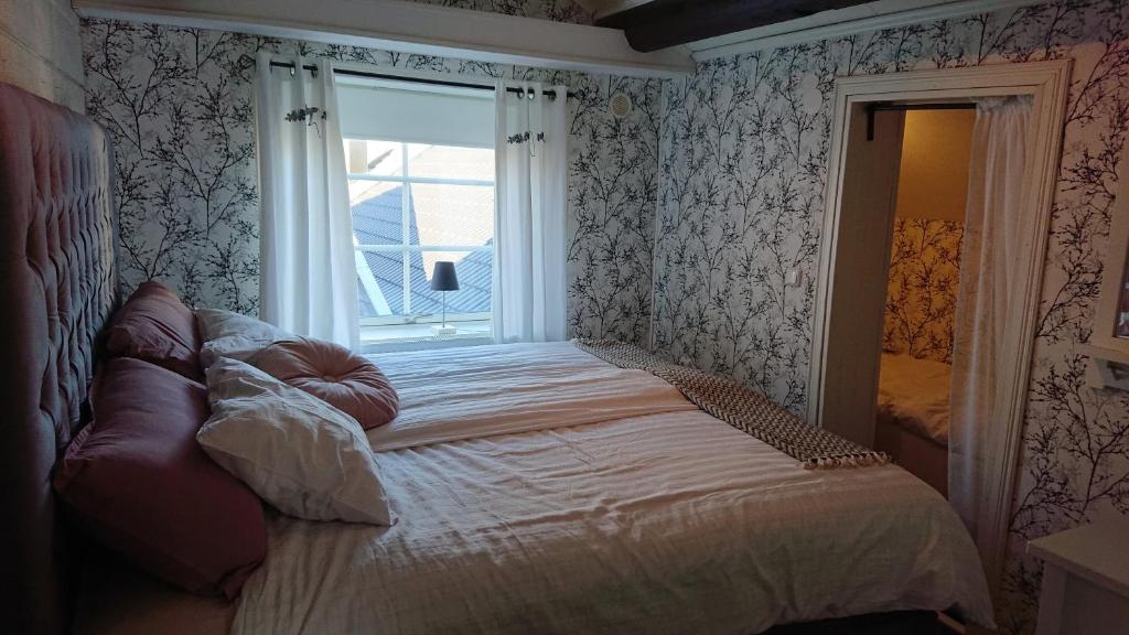 a bedroom with a bed in front of a window at Myntloftet med inglasad bubbelbad in Borlänge