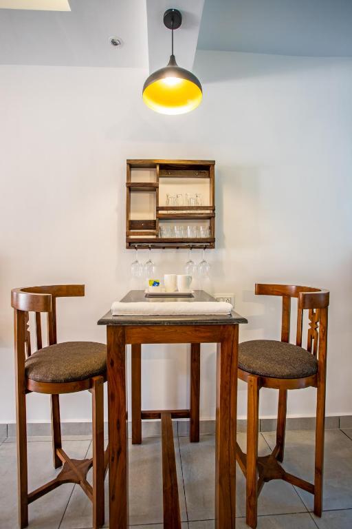 a dining room table with two chairs and a light at Whiteboard Homes Siolim in Siolim