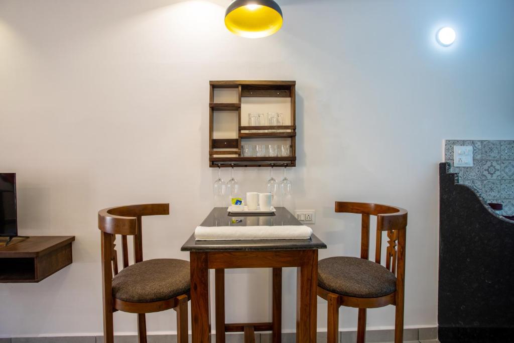 a table with two chairs and a table with a counter at Whiteboard Homes Siolim in Siolim