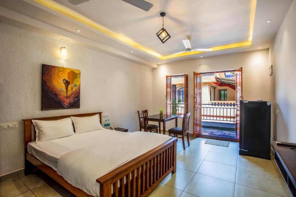 a bedroom with a bed and a table and a desk at Whiteboard Homes Siolim in Siolim