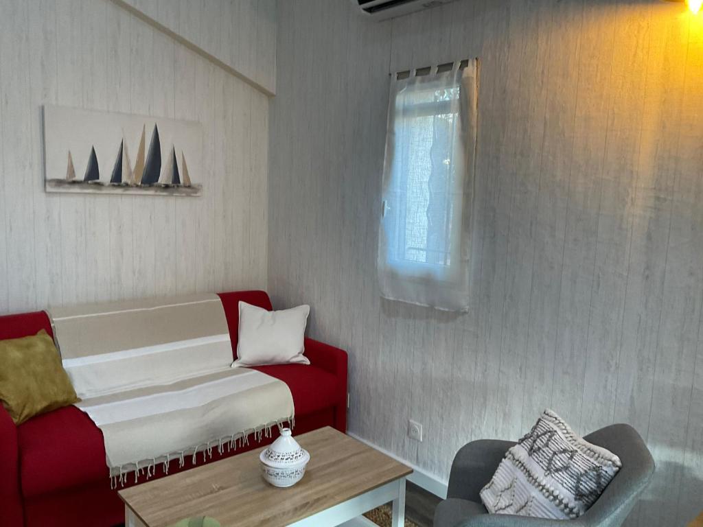 ein Wohnzimmer mit einem roten Sofa und einem Fenster in der Unterkunft Location maison de vacances à Sainte-Marie-Plage in Sainte-Marie