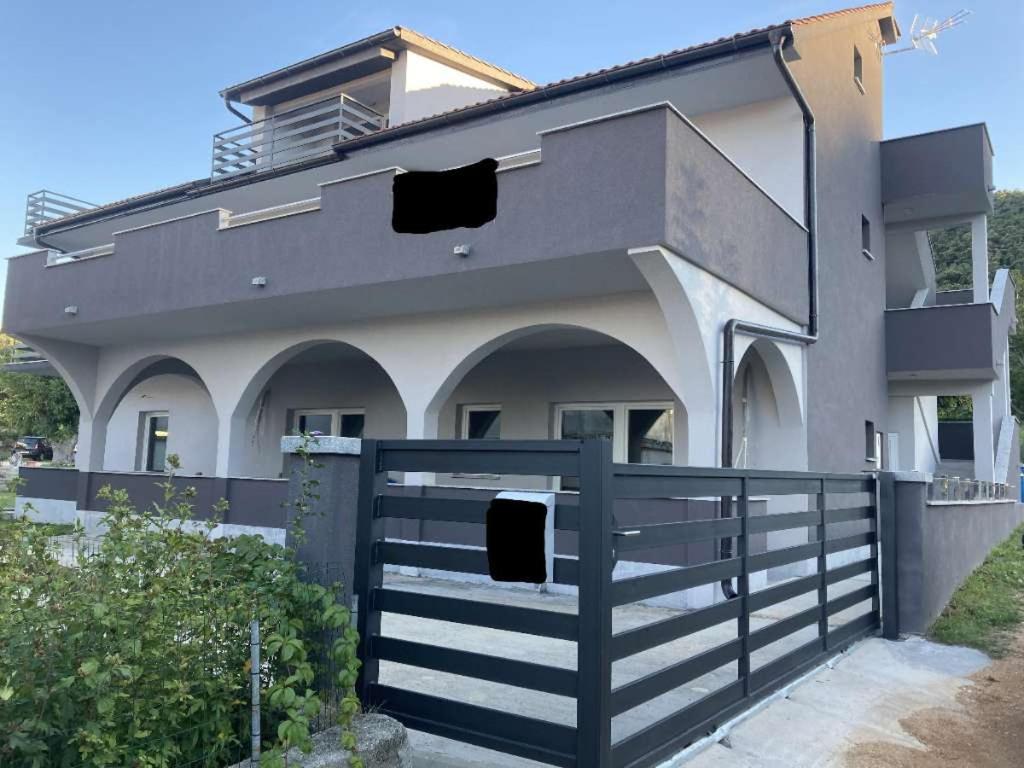 a house with a black fence in front of it at Apartment Julia in Supetarska Draga