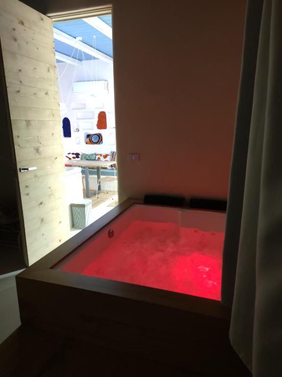 a hot tub with red water in a room at Casa Mediterranea Jacuzzi riscaldata con Caminetto in Specchiolla