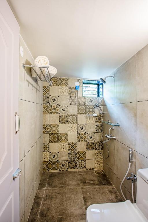a bathroom with a shower and a toilet at Whiteboard Homes Siolim in Siolim