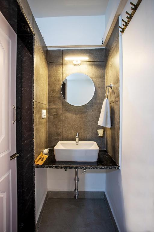 a bathroom with a sink and a mirror at Whiteboard Homes Siolim in Siolim