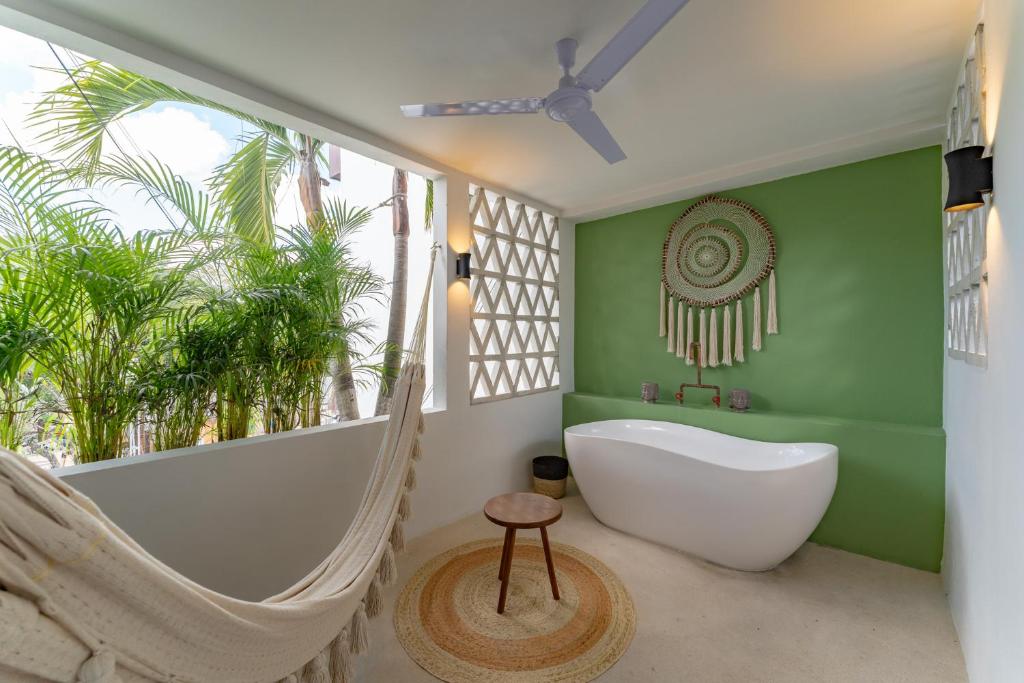 a bathroom with a hammock and a bath tub at Casa Yako in Playa del Carmen