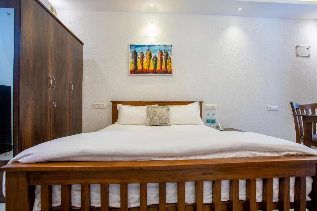 a bed in a bedroom with a picture on the wall at Whiteboard Homes Siolim in Siolim