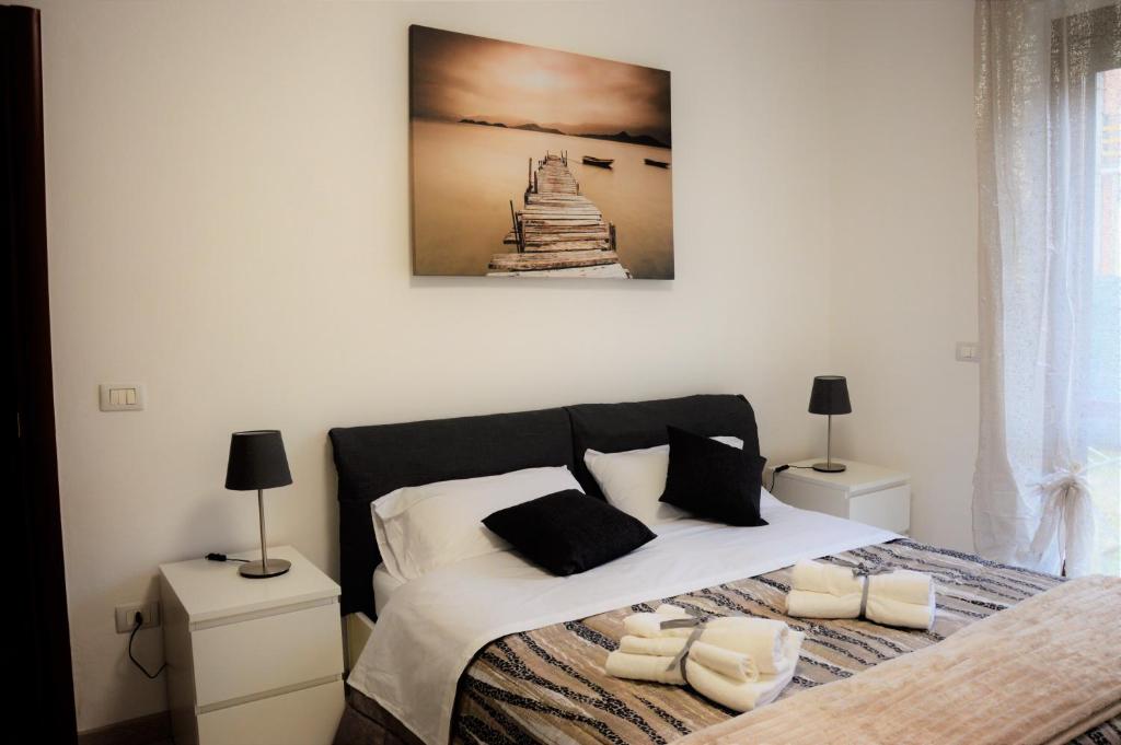 1 dormitorio con 1 cama con 2 lámparas y una foto en la pared en Albachiara, en Castiglione del Lago