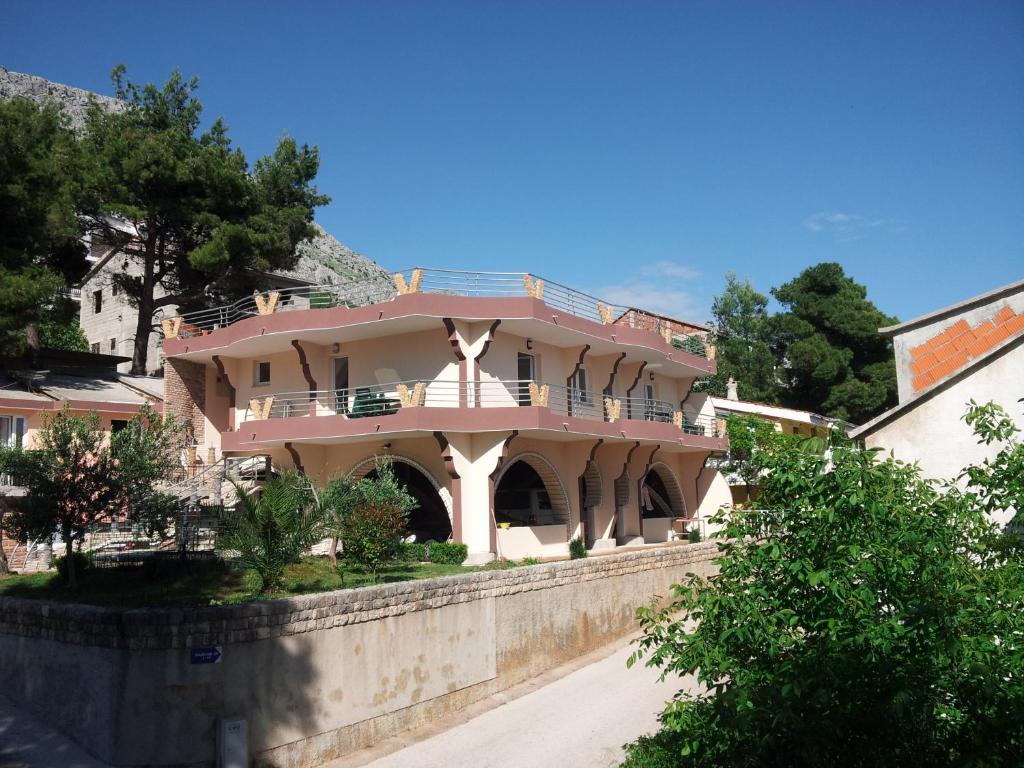 una gran casa rosa sobre una pared en Villa Perković, en Mimice