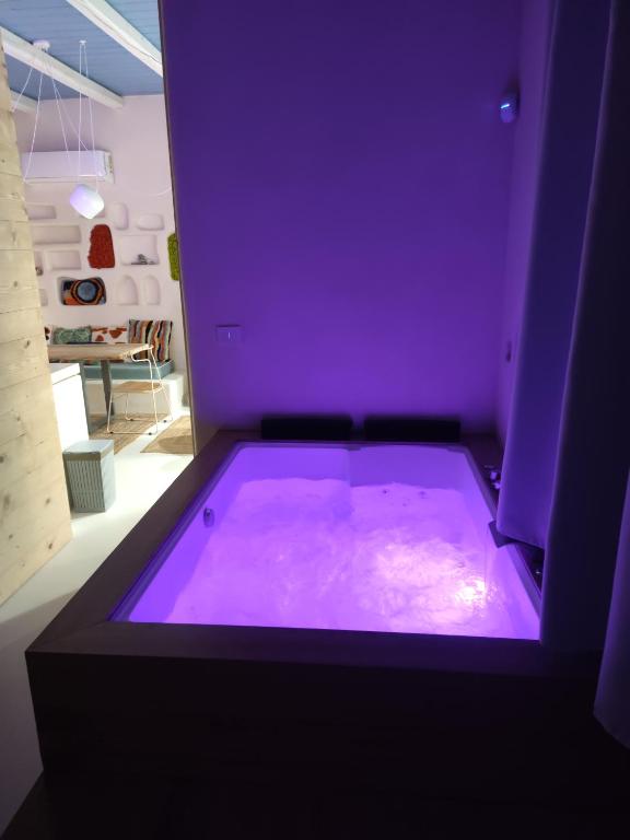 a purple bathtub in a living room with at Casa Mediterranea Jacuzzi riscaldata con Caminetto in Specchiolla