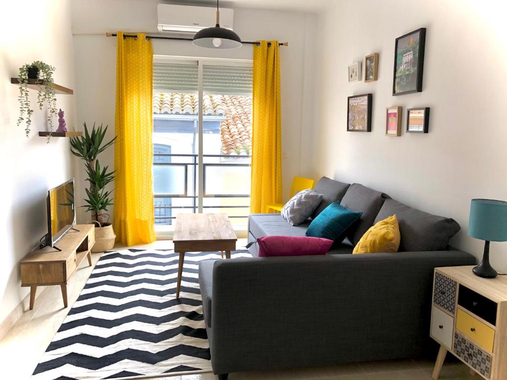 ein Wohnzimmer mit einem Sofa und einem Fenster in der Unterkunft Apartamentos Cruz Granada in Granada