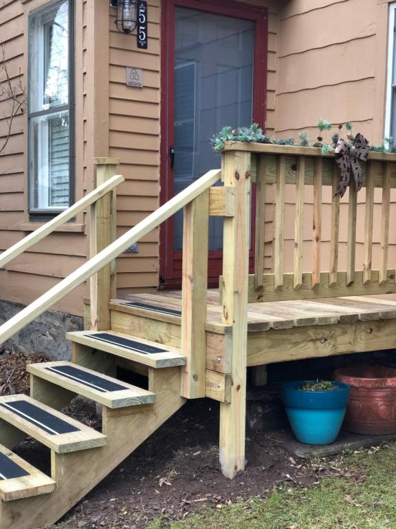 a wooden porch with stairs in front of a house at Homesteading at 55 main in Stamford