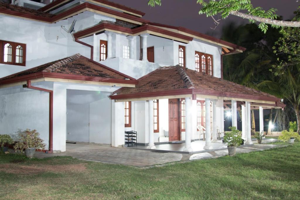 a large white house with a garage at night at Joy Lagoon Residence in Negombo