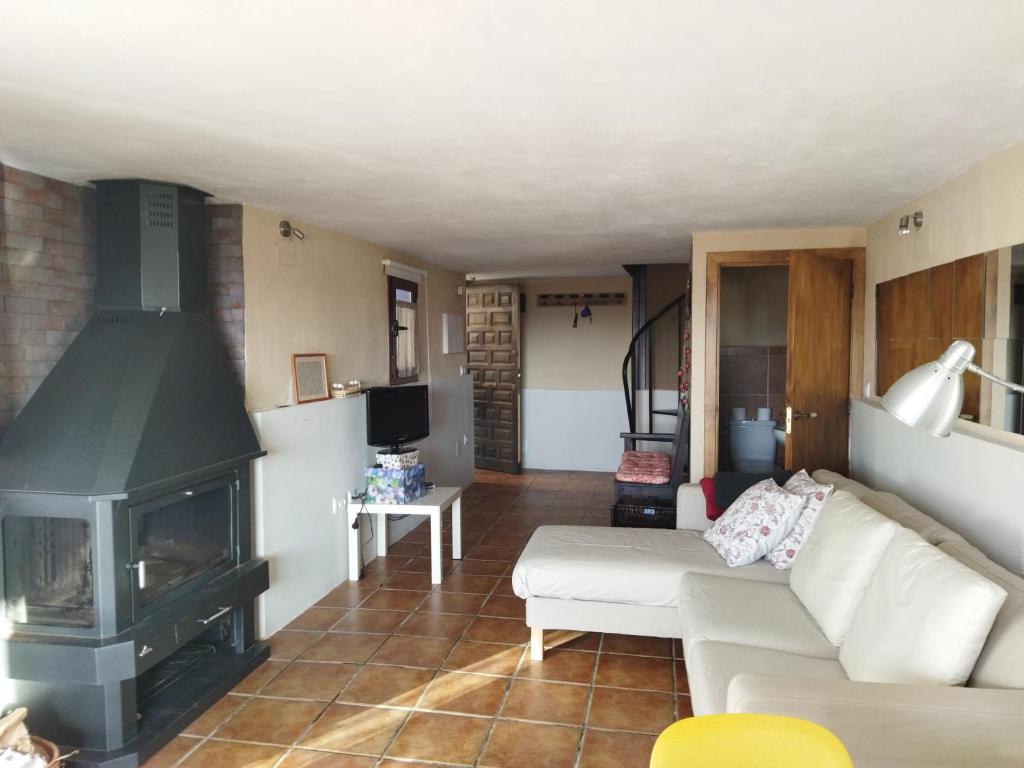 ein Wohnzimmer mit einem Sofa und einem Kamin in der Unterkunft Casa el Sereno in Salas Bajas