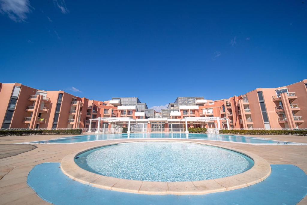 une grande piscine en face de certains immeubles d'appartements dans l'établissement Abis Cap corniche sejour cocooning dans un coin de paradis, à Sète