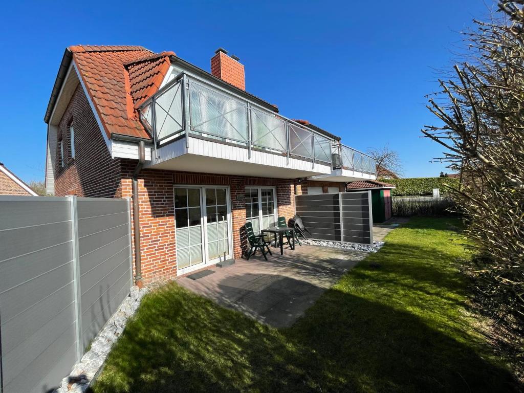 een huis met een glazen dak en een patio bij Ferienwohnung Hoffmann in Hooksiel