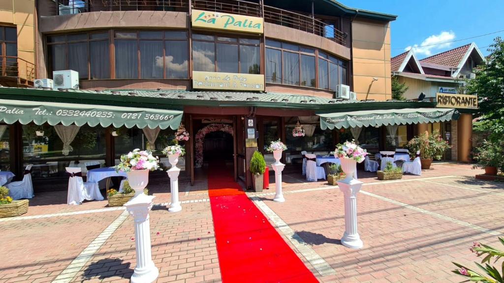 a red carpet in front of a building with a restaurant at Pensiunea La Palia in Iaşi