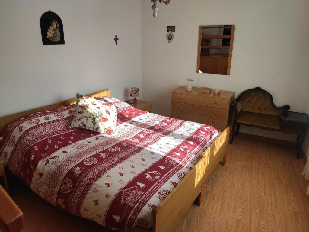 1 dormitorio con 1 cama con edredón rojo y blanco en Casa Gemma en Vignola