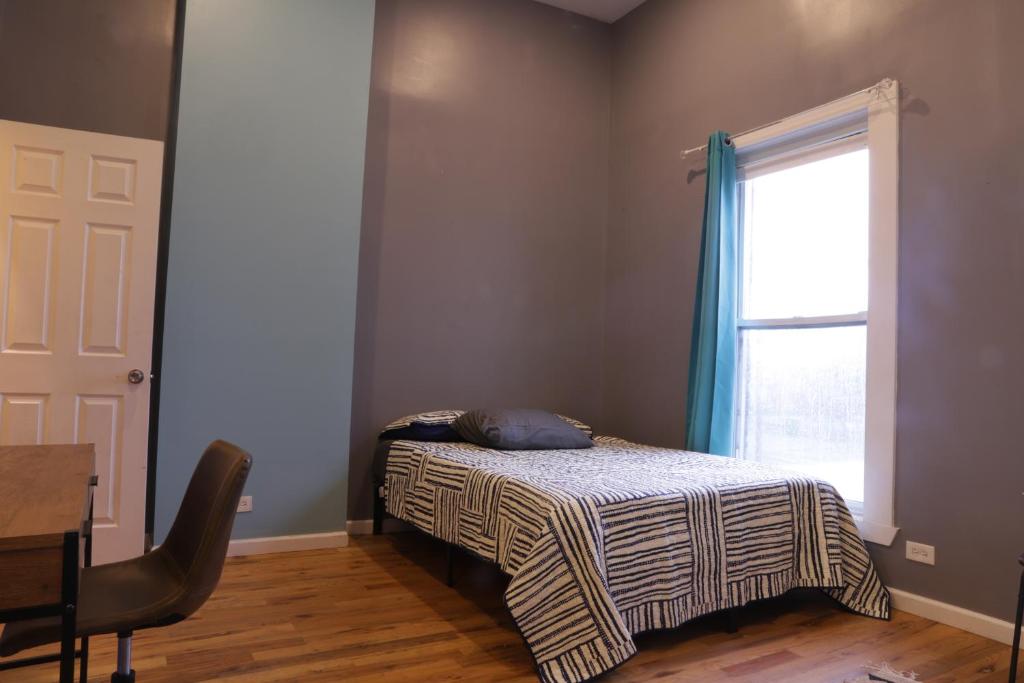 1 dormitorio con cama, escritorio y ventana en Langley, en Chicago