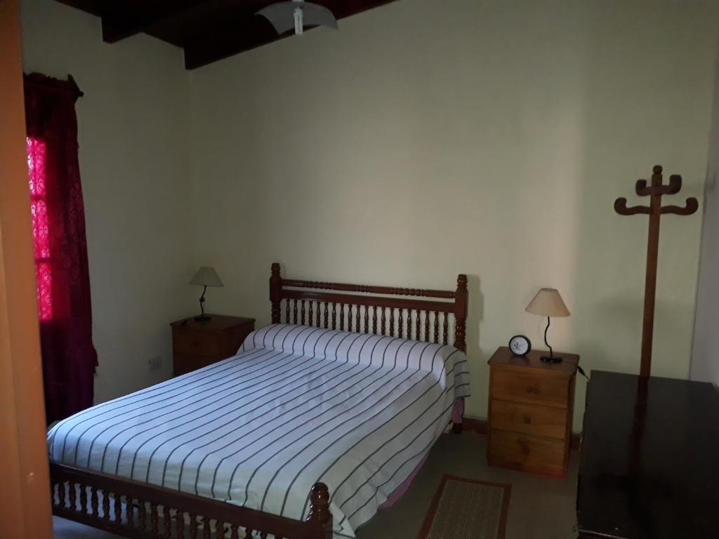 1 dormitorio con 1 cama y 1 cruz en la pared en Lo de Jorge en Payogasta