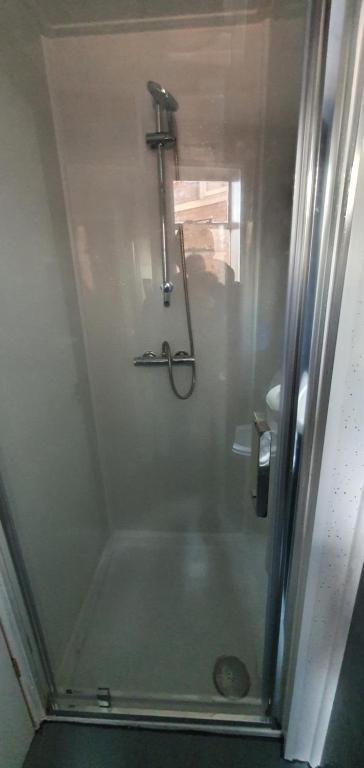 um chuveiro numa casa de banho com uma porta de vidro em En suite single bedroom, close to city centre em Sheffield