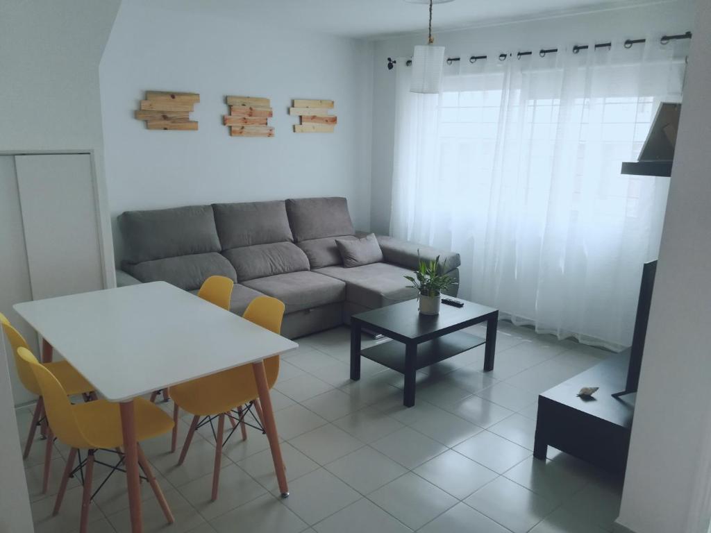 sala de estar con sofá, mesa y sillas en Franja de Mar - Duplex amplio y luminoso en Santa Cruz de la Palma