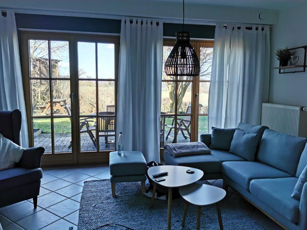 sala de estar con sofá azul y mesa en Ferienwohnung Auenland, en Braunfels