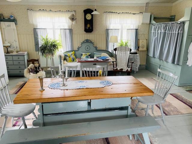 a living room with a wooden table and chairs at Pollin Piha in Töfsala