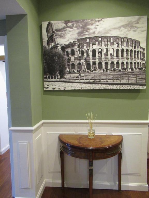 a room with a table and a picture of the coliseum at IMPERIAL FORUM RELAIS in Rome