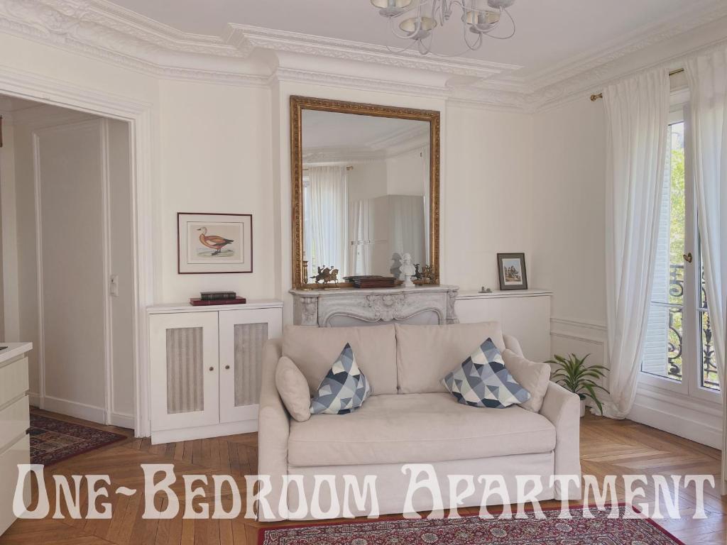 a living room with a couch and a mirror at Eiffel Tower view Residence in Paris